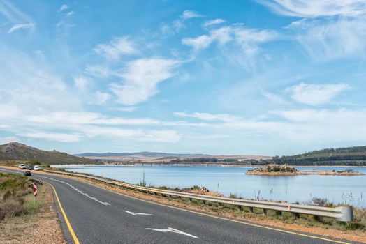The Theewaterskloof Dam in the Western Cape Province as seen from road R45. Vehicles and a road bridge are visible