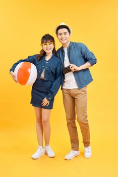 Lovely Asian couple in summer casual clothes and beach accessories studio shot isolated