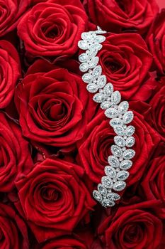 Gemstone jewellery, wedding fashion and luxe shopping concept - Luxury diamond bracelet and bouquet of red roses, jewelry love gift on Valentines Day and romantic holidays present