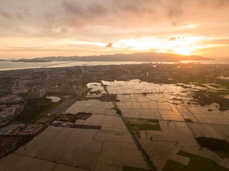 Dramatic sunset over paddy field at Perai. Background is Penang Bridge.