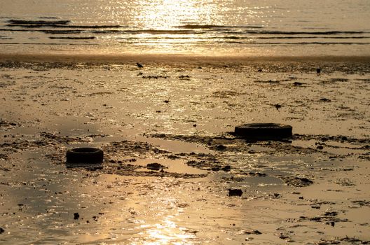 Old car tires at coastal in sunrise morning.