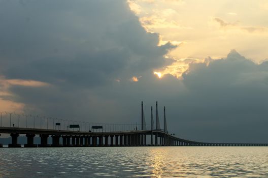 Sun rise through the cloud at Penang second bridge in morning.