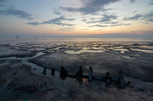 Broken ship near shoreline during dusk hour.