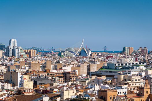 View at Valencia cityscape with sea port in distance. Downtown with rooftops of residential dwellings. Valencia downtown. Spain. Europe.