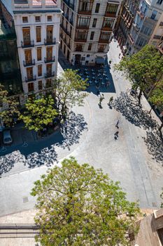 View at Valencia downtown with people walking in the street. Pedestrians in Placa dels Furs.. Spain. Europe.