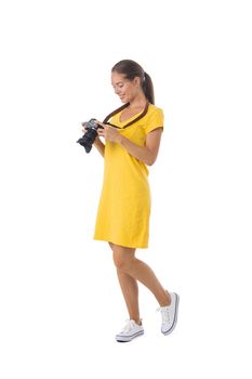 Young beautiful photographer girl in yellow dress with camera isolated on white background