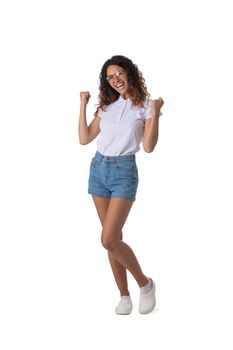 Happy girl winner in casual wear hold fists looking at camera, isolated over white background