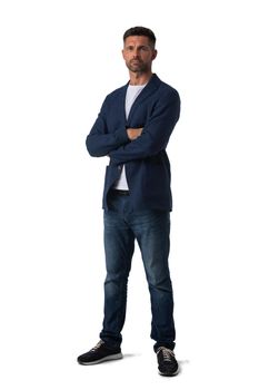 Full length portrait of mid adult serious business man in jeans and blue blazer with arms folded isolated on white background, casual people