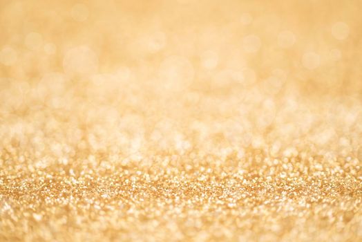 Detailed texture of golden glitter dust surface, luxury background with bokeh