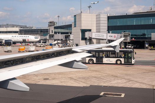05/26/2019. Frankfurt Airport, Germany. Transatlantic Air Canada airplane in front of main terminal and shuttle bus. Airport operated by Fraport and serves as the main hub for Lufthansa including Lufthansa City Line and Lufthansa Cargo.
