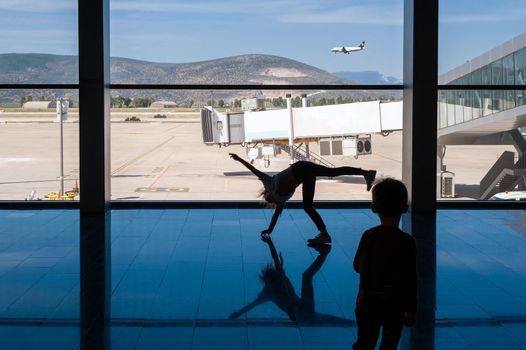 05/26/2019. Bodrum Airport / Milas Mugla Airport. Turkey. Small girl doing cartwheels exercise out of boredom while awaiting for her flight.