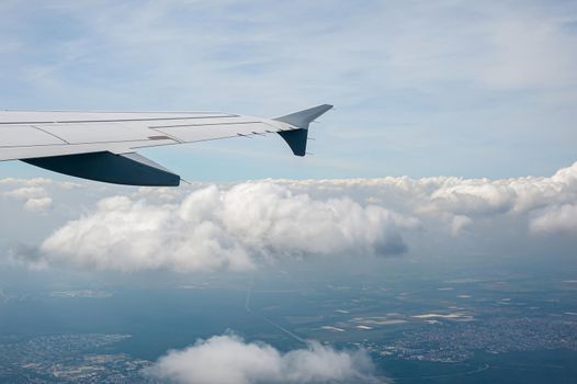 View from airborne airplane window at cloudy sky at high altitude.