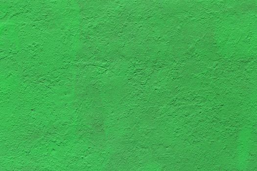 background and texture of flat thick painted matte green surface under direct sunlight - new paint over fragments of old peeled one