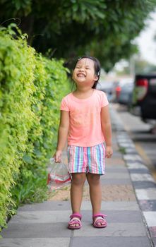 little girl walking on the footpath in car park