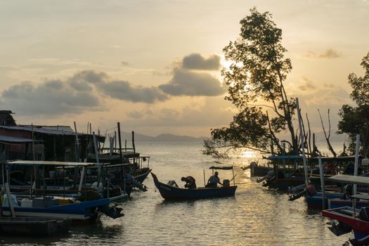 Bukit Mertajam, Penang/Malaysia - Mar 03 2017: A boat come back from sea at Malays fishing village during sun down.