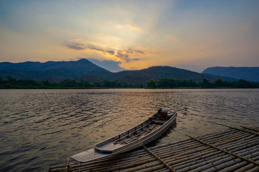 boats docked on a mountain lake with sunset.Natural dam lake in forest.