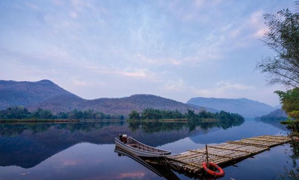 boats docked on a mountain lake and reflection.Natural dam lake in forest.