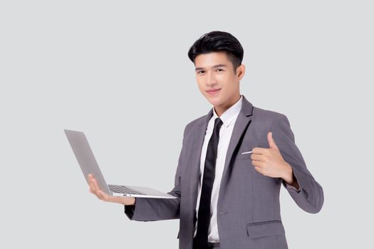 Young asian business man standing work on laptop computer to internet online isolated on white background, businessman confident and notebook, freelance with success, marketing and communication.