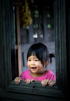 little girl looking at outside the window with shocked and fear of something