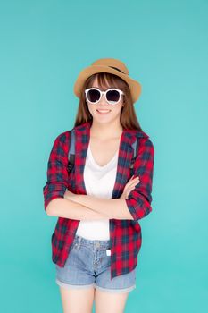 Beautiful portrait young asian woman wear sunglasses and hat smile expression confident enjoy summer holiday isolated blue background, model girl fashion having backpack, travel concept.