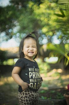 Little smiling child girl  standing with bokeh background