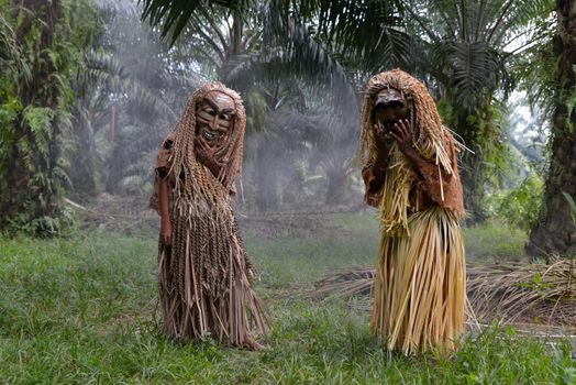 Carey Island, Selangor/Malaysia - Mar 17 2018: Malaysia's indigenous tribesmen wear mask in oil palm estate.