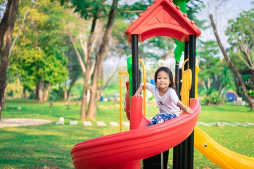 Asian little girl enjoys playing in a children playground