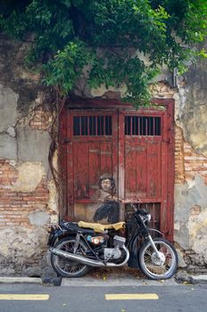 Georgetown, Penang/Malaysia - Feb 14 2020: Mural kid on old motorcycle.