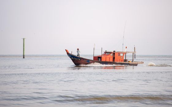 Sekinchan, Selangor/Malaysia - Oct 06 2019: A fisherman stand in front of boat go back home.