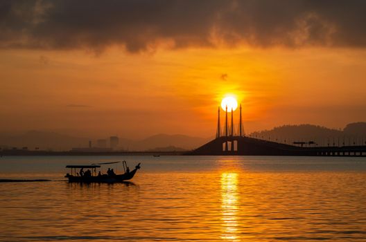 Georgetown, Penang/Malaysia - Feb 16 2020: A boat move at Penang Bridge during sunrise.