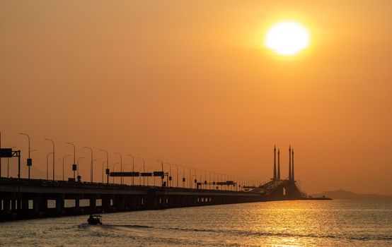 Georgetown, Penang/Malaysia - Mar 03 2020: Orange sun rise up at Penang Bridge.