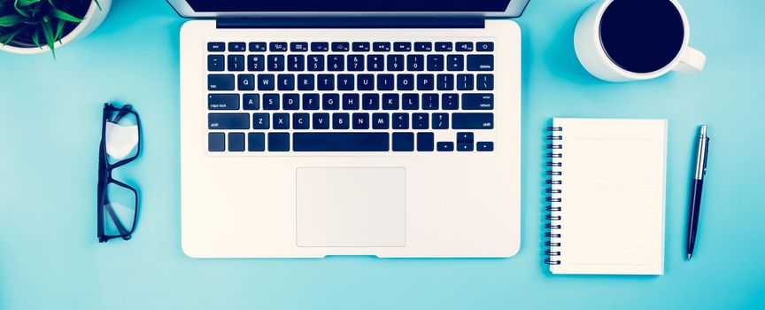 Flat lay of laptop computer and plant and cup of coffee on desk in office, workplace and notebook and glasses and potted tree and book, workspace and copy space, top view, business concept.