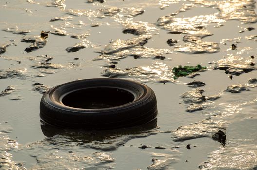 Batu Maung, Penang/Malaysia - Dec 28 2019: Car tire and other rubbish at sea in sunlight morning.