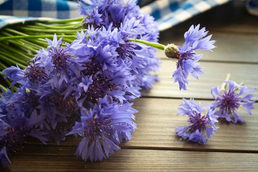 Bouquet of beautiful cornflowers on dark table, closeup