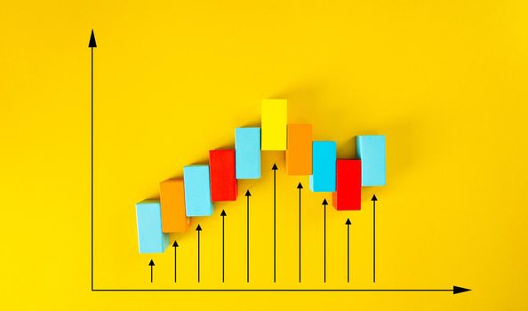 Wooden blocks arranged in an increasing graph on yellow background. Business growth, career growth or growth concept.