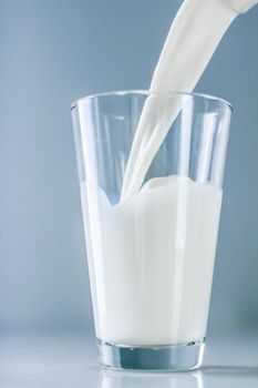 Dairy, healthy nutrition and breakfast concept - World Milk Day, pouring into glass on marble table