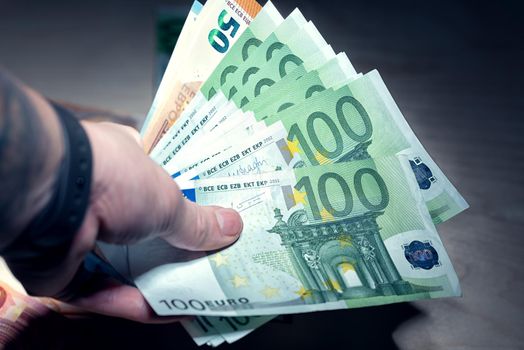 Heap of green houndred euro banknotes in the hand