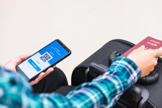 Vaccination passport, Traveler man holding health passport of vaccination certification on smartphone app at airport before boarding plane during coronavirus pandemic, Mobile app of virus COVID-19