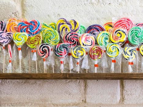 Colorful spiral lollipops over a shop shelf