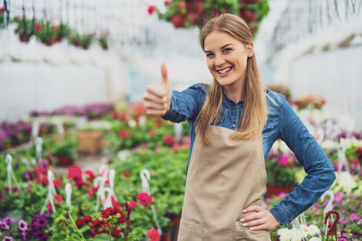 Woman is owning small business greenhouse store. Female entrepreneur.