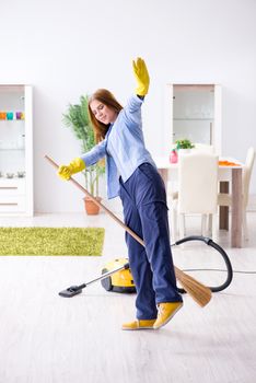 Young woman cleaning floor at home doing chores