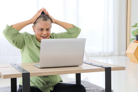 Senior Asian women Raise your glee while chatting via video call Concept Get good news online Get better insurance, pension service offer. Or talk to a family far away from each other in the room