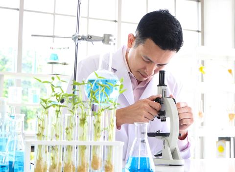 Asian scientists or chemists use a microscope. In science experiment Medical pharmaceutical research concept DNA structure, innovation and technology