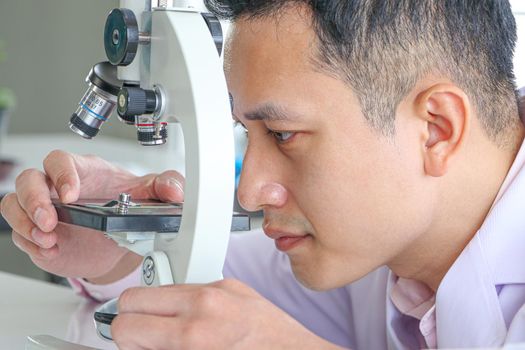 Asian scientists or chemists use a microscope. In science experiment Medical pharmaceutical research concept DNA structure, innovation and technology