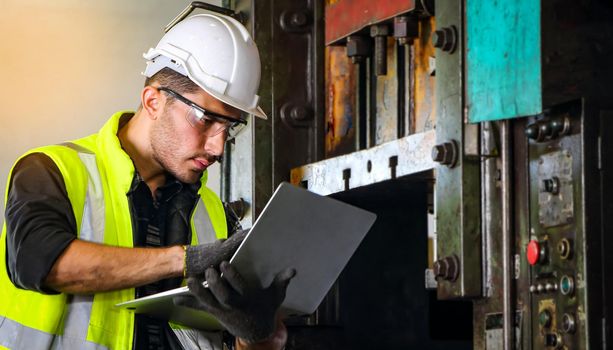 A professional male engineer wearing a uniform and glasses uses a laptop to find maintenance information. And installation of machines in industrial plants With confidence Concept of engineering