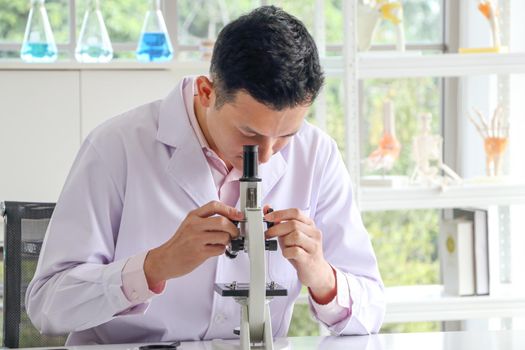 Asian scientists or chemists use a microscope. In science experiment Medical pharmaceutical research concept DNA structure, innovation and technology