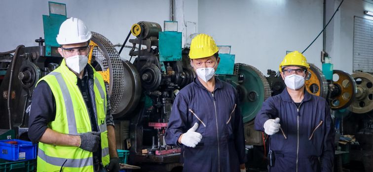 A male worker wearing a mask that protects against COVID 19, the concept of preventing the spread of COVID, or COVID while working. Maintenance and installation of industrial machinery