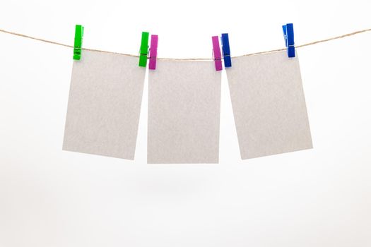 Empty paper sheets for notes, frames that hang on a rope with clothespins, collection of various notes, Mockup template for memories, and a clothes pegs on white background. Blank cards on the rope.