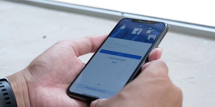 CHIANG MAI ,THAILAND MAY 18 2021 : Woman holding a iPhone X with social Internet service Facebook on the screen..