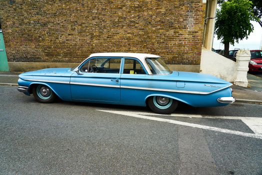 A blue 1961 4 door Chevrolet Bel Air sedan with chrome bumpers